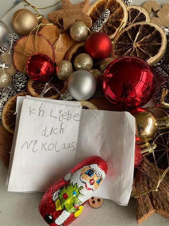Weihnachtsdekoration, ein Schokoladen-Nikolaus und ein Brief in Kinderschrift: Ich liebe Dich Nikolaus